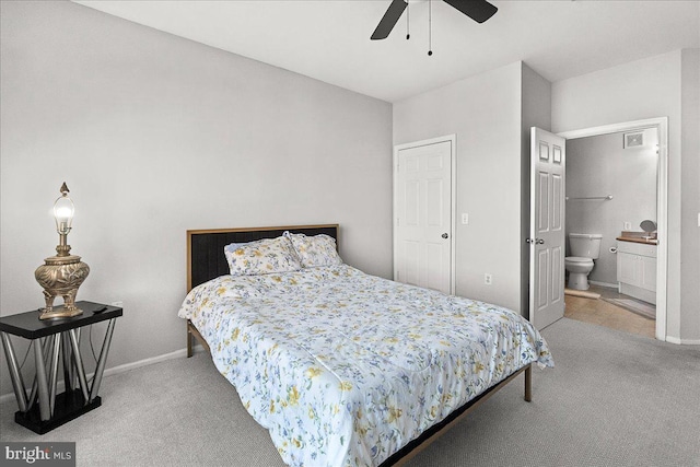 carpeted bedroom with ceiling fan, connected bathroom, and baseboards