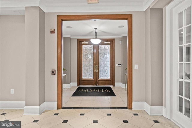 tiled foyer with ornamental molding, french doors, and baseboards