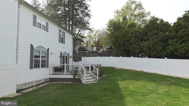 view of yard featuring fence and a deck