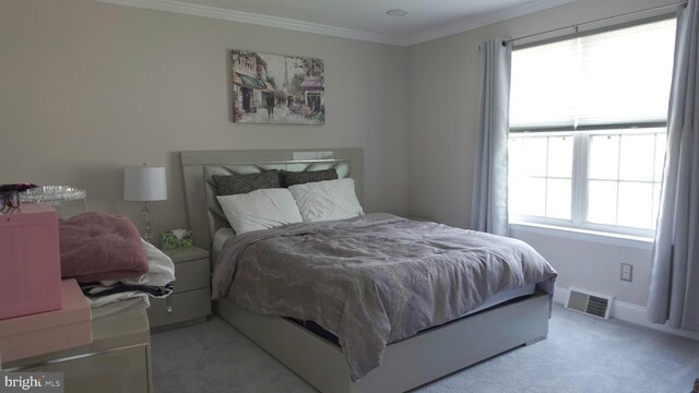 bedroom featuring visible vents, light carpet, and crown molding