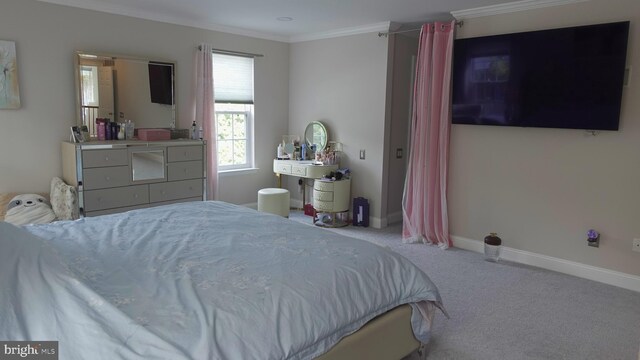 carpeted bedroom with ornamental molding and baseboards