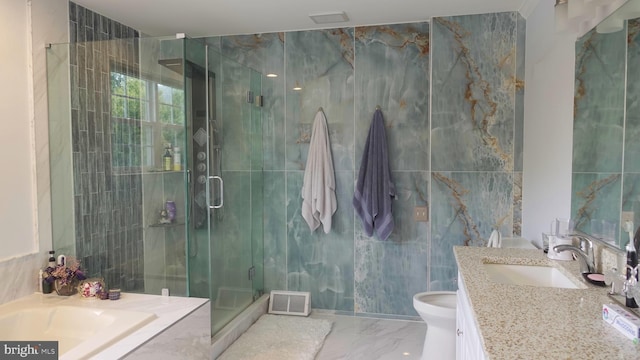 bathroom with marble finish floor, tile walls, vanity, visible vents, and a stall shower