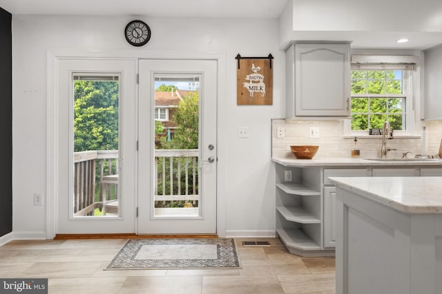 doorway with a sink, baseboards, healthy amount of natural light, and recessed lighting