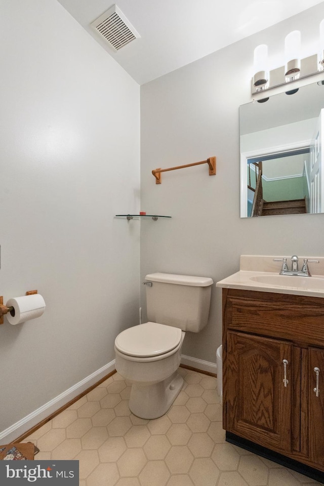 bathroom featuring baseboards, toilet, tile patterned flooring, and vanity