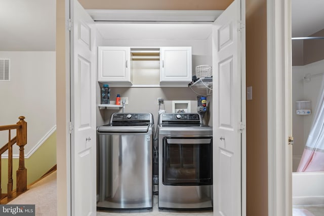 clothes washing area with cabinet space and washing machine and dryer