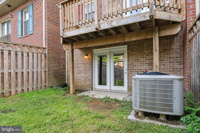rear view of house featuring central air condition unit, a balcony, and brick siding