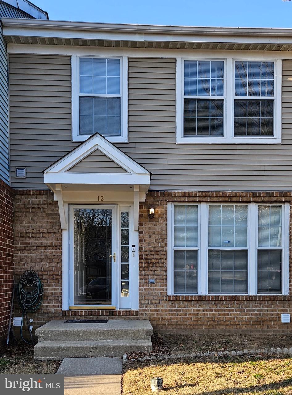 doorway to property featuring brick siding