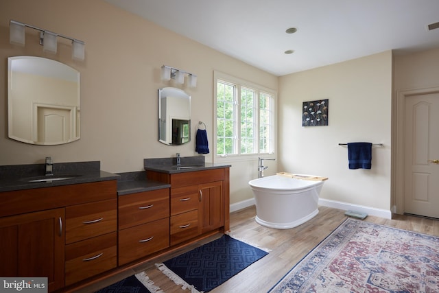 15410 River Rd, Darnestown, MD 20874 - full bathroom featuring double vanity, wood finished floors, a soaking tub, and baseboards