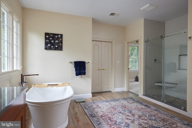 15410 River Rd, Darnestown, MD 20874 - bathroom featuring wood finished floors, a shower stall, a soaking tub, and baseboards