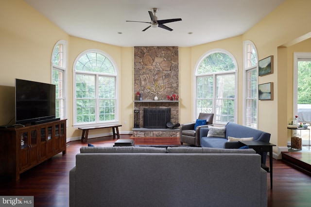 15410 River Rd, Darnestown, MD 20874 - living area featuring dark wood-style flooring, ceiling fan, a stone fireplace, and baseboards