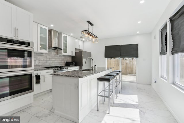217 Grape St, Philadelphia, PA 19128 - kitchen featuring wall chimney range hood, dark stone countertops, stainless steel appliances, and marble finish floor