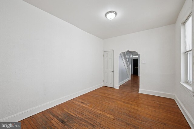 spare room featuring baseboards and hardwood / wood-style flooring