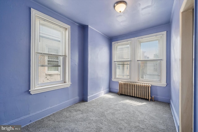 unfurnished room with baseboards, radiator heating unit, carpet flooring, and plenty of natural light