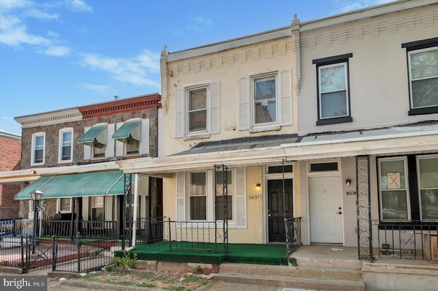 multi unit property with brick siding and a porch