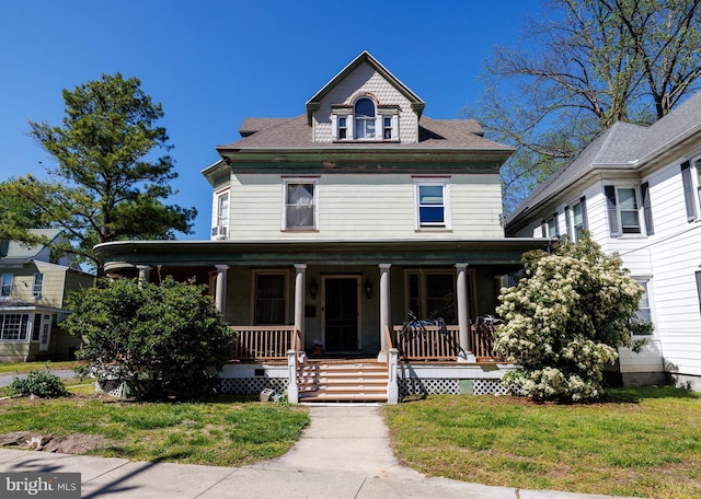 view of front of property with covered porch and a front lawn