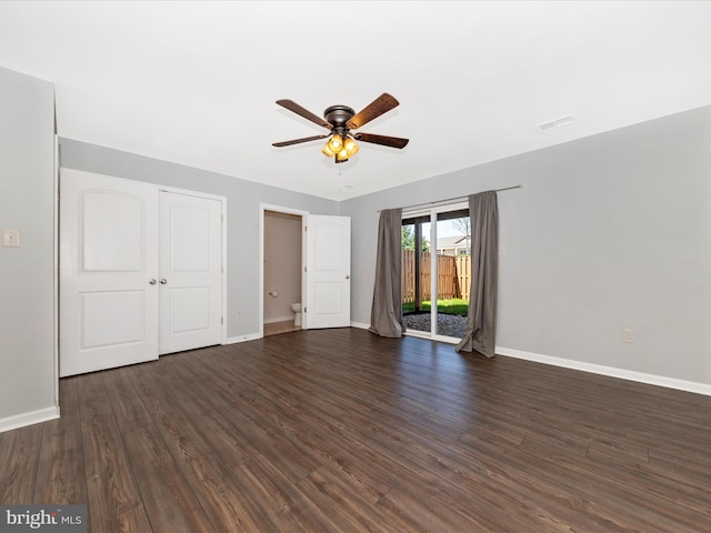 interior space featuring ceiling fan, visible vents, dark wood-style floors, and baseboards