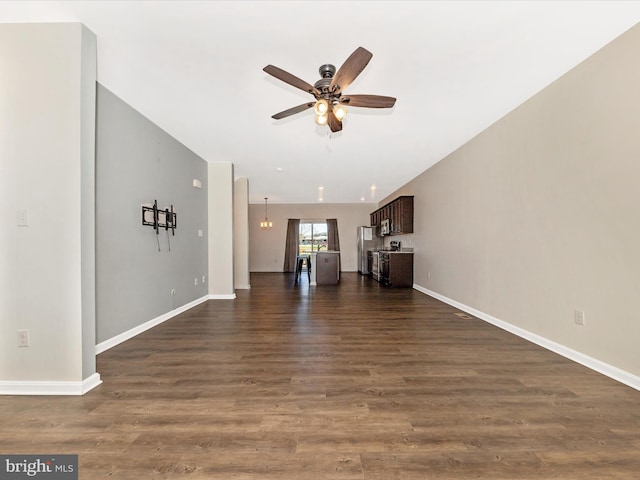 unfurnished living room featuring baseboards, ceiling fan, and dark wood-type flooring