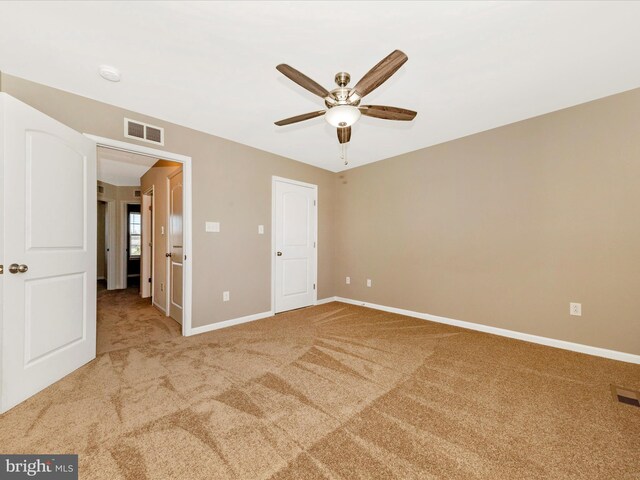 unfurnished bedroom featuring visible vents, a ceiling fan, carpet, and baseboards