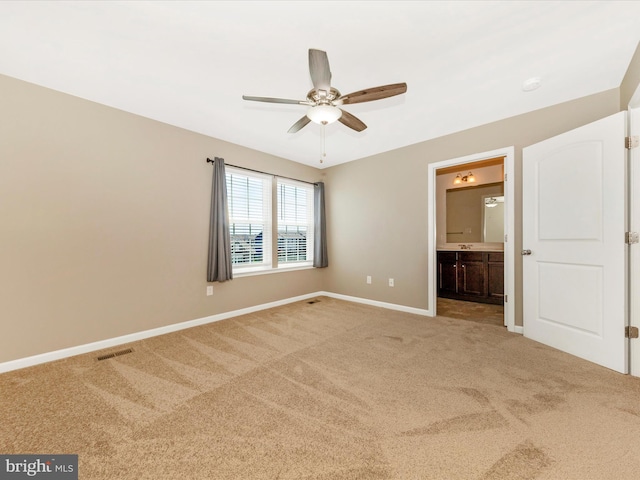 unfurnished bedroom with ceiling fan, visible vents, baseboards, ensuite bathroom, and carpet flooring
