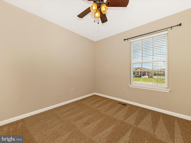 empty room with baseboards, ceiling fan, carpet flooring, and visible vents