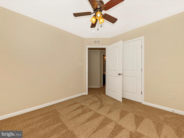 unfurnished bedroom with carpet floors, baseboards, visible vents, and ceiling fan