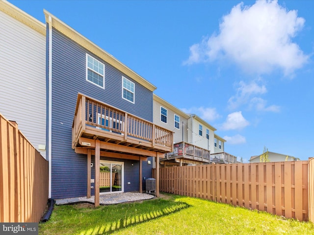 back of house featuring a deck, a patio, a fenced backyard, central air condition unit, and a yard