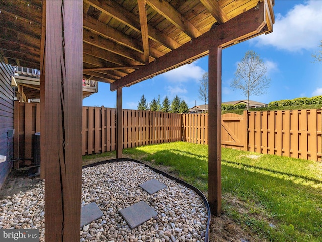 view of yard with a fenced backyard and a gate