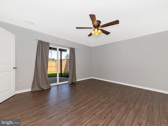 empty room with visible vents, dark wood-style flooring, ceiling fan, and baseboards
