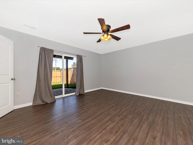 unfurnished room with baseboards, a ceiling fan, dark wood finished floors, and visible vents