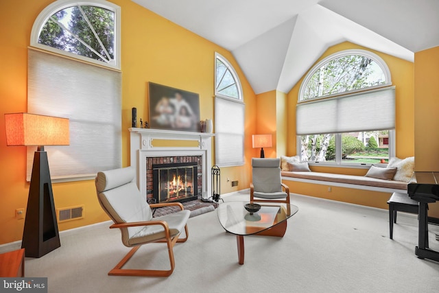 living area with visible vents, a healthy amount of sunlight, and a fireplace
