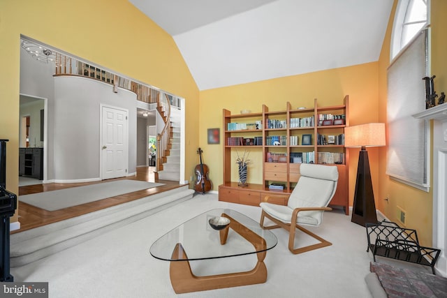 living area featuring high vaulted ceiling, stairs, carpet flooring, and plenty of natural light