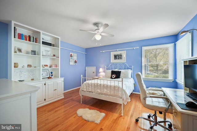 bedroom with a ceiling fan, baseboards, and light wood-type flooring
