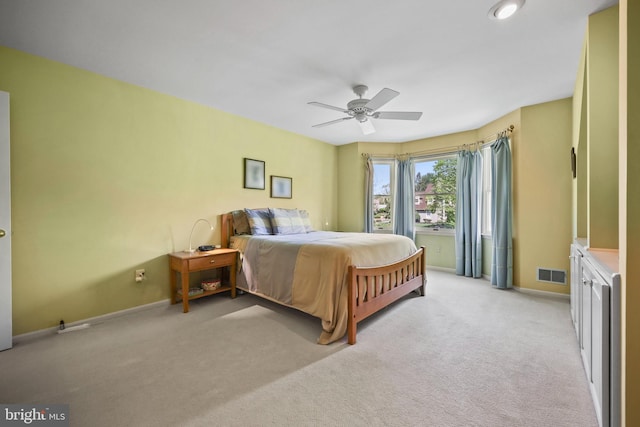 bedroom featuring a ceiling fan, visible vents, light carpet, and baseboards