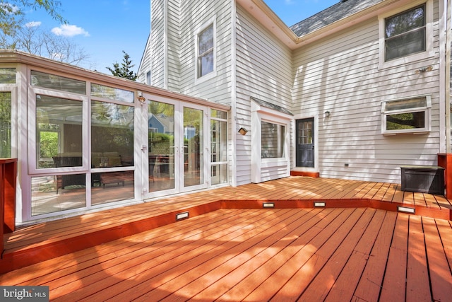 wooden deck with a sunroom