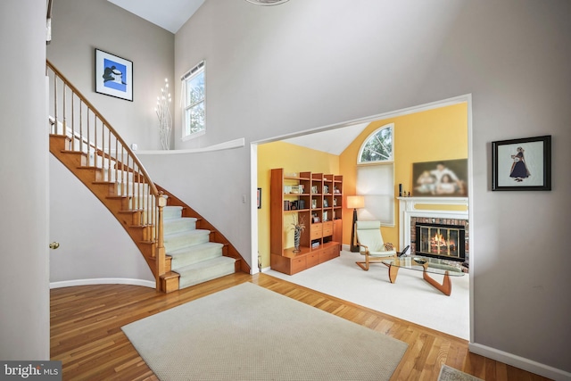 living area with stairs, a healthy amount of sunlight, and a high ceiling