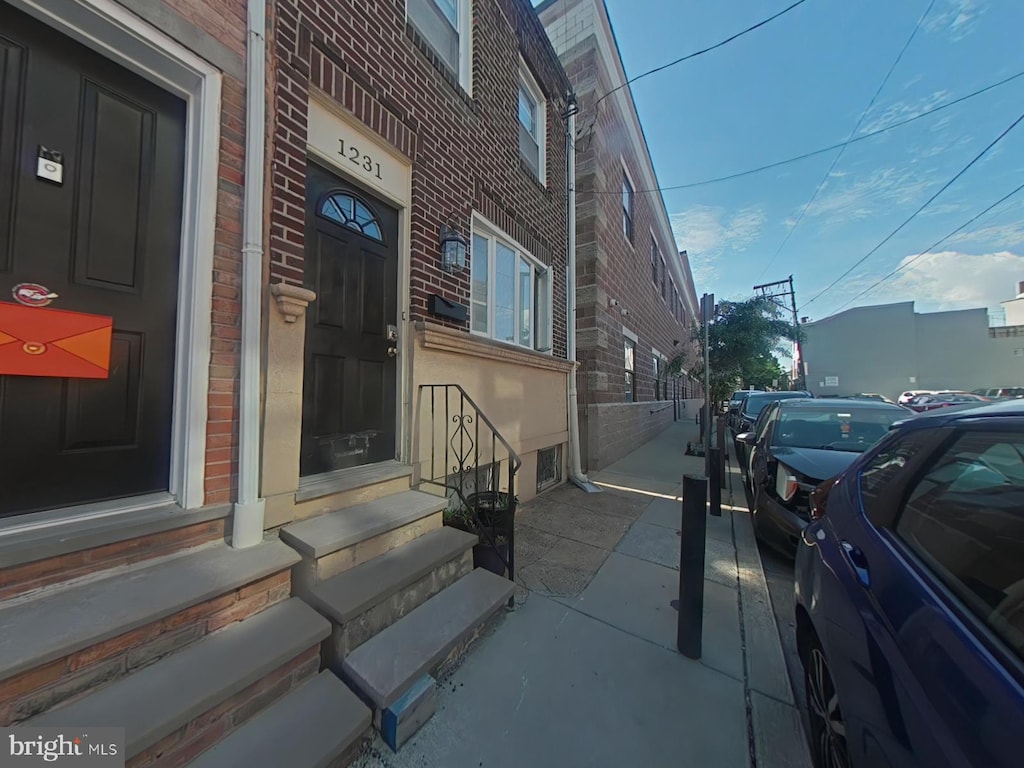 entrance to property featuring brick siding