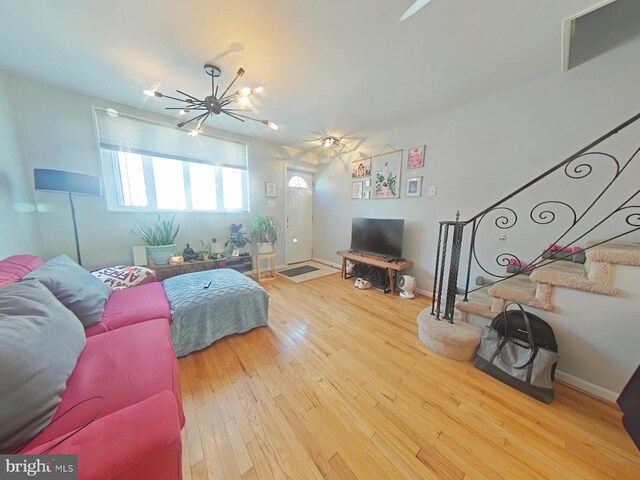 1231 S Clarion St, Philadelphia, PA 19147 - living room with stairs, wood-type flooring, a chandelier, and baseboards