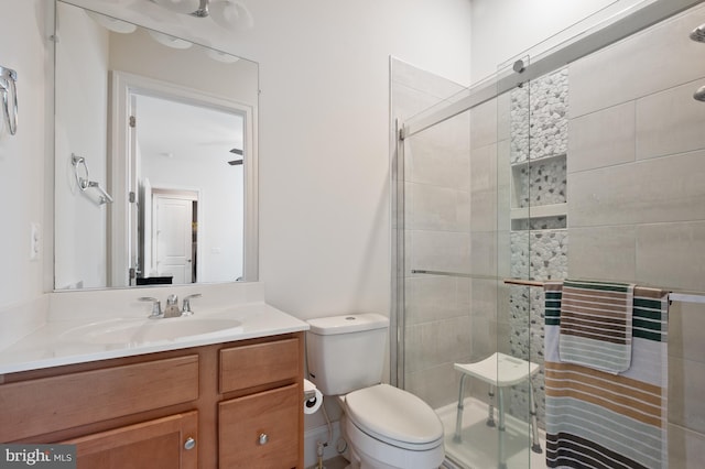bathroom with vanity, toilet, and a stall shower