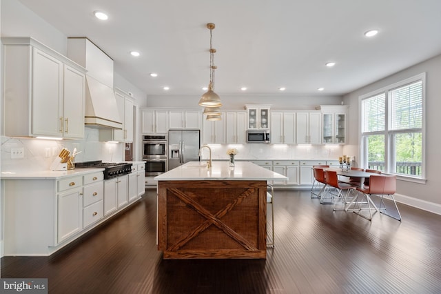 kitchen featuring tasteful backsplash, light countertops, stainless steel appliances, white cabinetry, and dark wood-type flooring