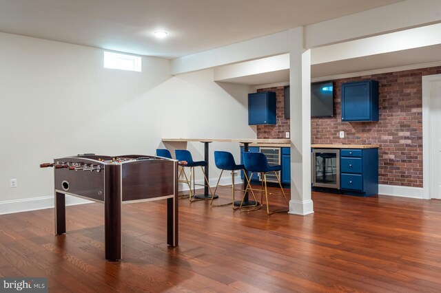 recreation room with baseboards, dark wood finished floors, and wine cooler