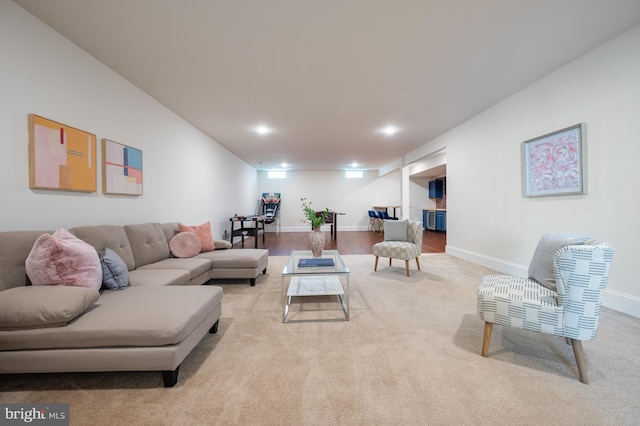 living area featuring baseboards and light carpet