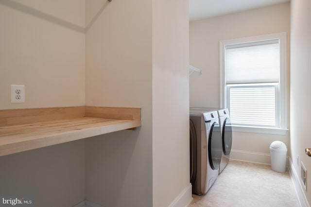 washroom featuring baseboards, laundry area, and washing machine and clothes dryer