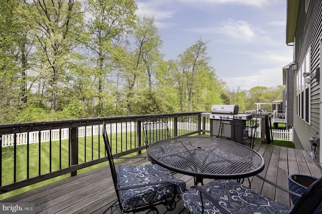 wooden deck featuring a yard, outdoor dining area, and area for grilling
