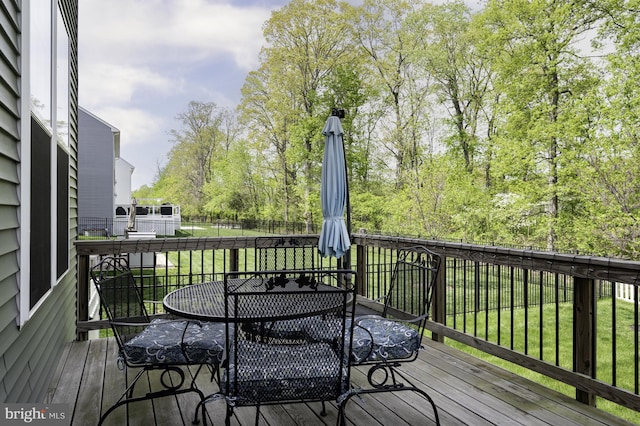 deck featuring a lawn and outdoor dining space