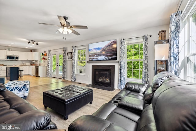 living room with a fireplace with flush hearth, ceiling fan, light wood-type flooring, and recessed lighting