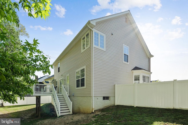 view of property exterior with a deck, crawl space, stairs, and fence