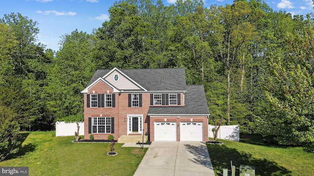 view of front of home with brick siding, fence, a front yard, and concrete driveway