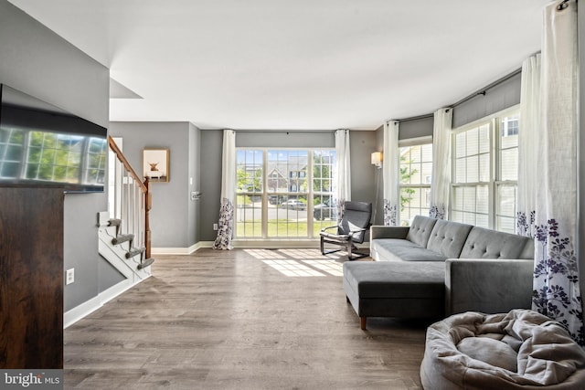 living area featuring stairway, wood finished floors, and baseboards