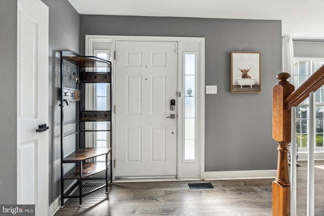 entrance foyer featuring baseboards, visible vents, and wood finished floors