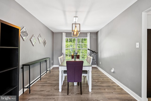 dining space with baseboards and wood finished floors